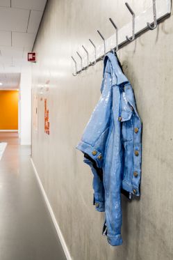 Rock'n' roll i keramik, bronze og broderi</br>På Frederiksbjerg Skole. Her finder man et siddemøbel af grønne mælkekasser - lavet i bronze, en efterladt Fjällräven skoletaske i bronze og cowboyjakke på en knage også i bronze. </br>Foto: Jens Peter Engedal